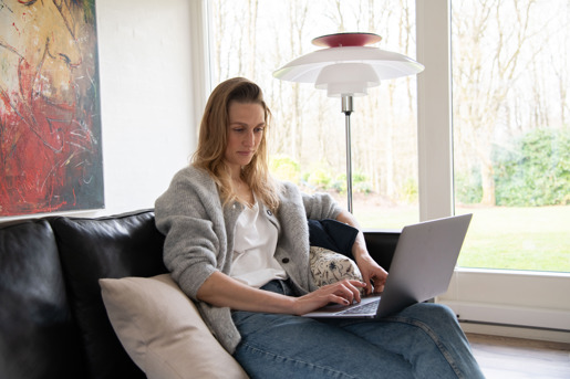 Ung kvinde sidder med en computer