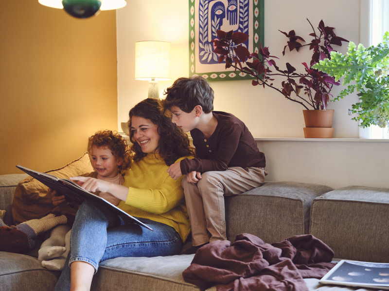 Mor og børn sidder i stuen