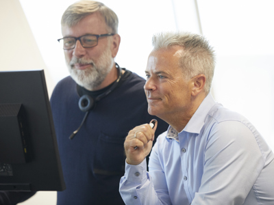 To NRGi Rådgivere ved en computer