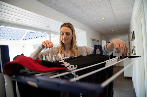 NRGi kvinde hænger vasketøj på tørrestativ