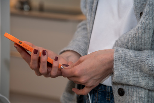 Kvinde tager stikket fra sin oplader ud af sin mobil